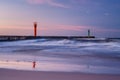 Beautiful sunset with lighthouse and blue clouds over the sea Royalty Free Stock Photo