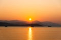 Beautiful sunset with mountain and speed boat, yacht at pier over horizon summer sea in evening background. Royalty Free Stock Photo