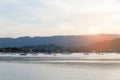 Beautiful sunset with mountain and speed boat, yacht at pier over horizon summer sea background evening. Royalty Free Stock Photo