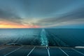 Beautiful sunset ocean view of the horizon with ship`s wake seen from the back of a cruise ship.