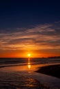 The beautiful sunset, orange blue sky and clouds over the Blyth Beach. St. Mary`s Lighthouse and Seaton Sluice village Royalty Free Stock Photo