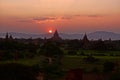 Beautiful sunset over Bagan temples and pagodas in valley, Burma Myanmar. Sun dipping below the horizon and mountains Royalty Free Stock Photo