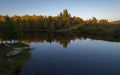 Colorful autumn landscape with lake and boat on background at sunset Royalty Free Stock Photo