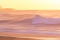 Beautiful sunset over calm ocean and waves in orange and pink