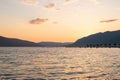 Beautiful sunset over coastal hills and sea with colorful evening clouds and palm trees Royalty Free Stock Photo