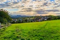 Beautiful sunset over countryside landscape of rolling hills with sun beams piercing sky and lighting hillside Royalty Free Stock Photo