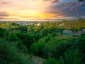 Beautiful sunset over countryside landscape of rolling hills with sun beams piercing sky and lighting hillside Royalty Free Stock Photo