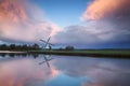 Beautiful sunset over Dutch windmill by river Royalty Free Stock Photo