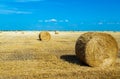 Beautiful sunset over farm field with many hay bales with blue sky and colorful clouds in background. Royalty Free Stock Photo