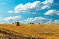 Beautiful sunset over farm field with many hay bales with blue sky and colorful clouds in background. Royalty Free Stock Photo