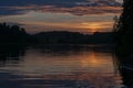 Beautiful sunset over a forest lake. Reflection of the setting sun in the quiet waters of a forest lake. Late sunset. Royalty Free Stock Photo