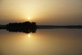 Beautiful sunset over the forest lake. Windless evening. Horizon. Reflection