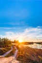 Beautiful sunset over the horizon. Country road near river Royalty Free Stock Photo