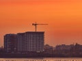 Beautiful sunset over Lake DÃÂ¢mboviÃâºa Lacul Morii in Bucharest, Romania. Sunset over a lake with a construction crane in the