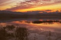 Beautiful sunset over lake in the winter.Mountains in background. Royalty Free Stock Photo