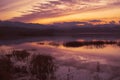 Beautiful sunset over lake in the winter.Mountains in background. Royalty Free Stock Photo