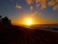 Beautiful Sunset over the ocean and beach with waves moving to shore and foot prints in the sand Royalty Free Stock Photo