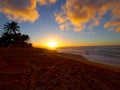 Beautiful Sunset over the ocean and beach with waves moving to shore and foot prints in the sand Royalty Free Stock Photo