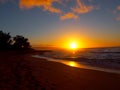 Beautiful Sunset over the ocean and beach with waves moving to shore and foot prints in the sand Royalty Free Stock Photo