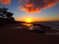 Beautiful Sunset over the ocean and beach with waves moving to shore and foot prints in the sand Royalty Free Stock Photo