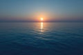 Beautiful sunset over the ocean. The orange disk of the sun sets behind the horizon in an atmosphere of peace and quiet Royalty Free Stock Photo