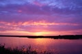 Beautiful sunset over the river. Magical sunrise behind colorful clouds over the lake. Calm water in a pond on the backdrop Royalty Free Stock Photo