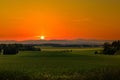 Beautiful sunset over rural field and hills on a horizon Royalty Free Stock Photo