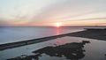 Beautiful sunset over sea with coast, road and lone car on it