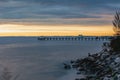 Beautiful sunset over the sea and a dock with a boat around it. Royalty Free Stock Photo