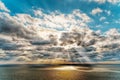 Beautiful sunset over the sea with reflection in the water, majestic clouds in the sky. Golden sun-the road to the sea, the spots Royalty Free Stock Photo