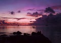 Beautiful sunset over the sea. Silhouettes of a couple against the backround of the evening ocean. Purple colored sky. Royalty Free Stock Photo