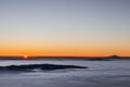 Beautiful sunset over a valley filled by fog with mountains and hills Royalty Free Stock Photo