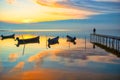 Beautiful sunset over water and silhouette of fishing boat Royalty Free Stock Photo