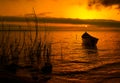 Beautiful sunset over water and silhouette of fishing boat Royalty Free Stock Photo