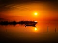 Beautiful sunset over water and silhouette fishing boat Royalty Free Stock Photo