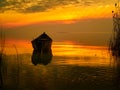 Beautiful sunset over water and silhouette of fishing boat Royalty Free Stock Photo