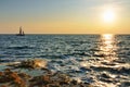 Beautiful sunset over wavy Black sea rocky coastline and yacht at horizon Royalty Free Stock Photo