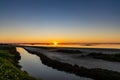 Sunset over wetlands and marshlands with a colorful sky and a sun star on the horizon Royalty Free Stock Photo