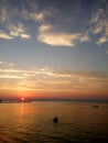 Beautiful sunset at Peraia, suburb of Thessaloniki, Greece. Silhouettes swimming in the sea. Royalty Free Stock Photo