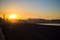 Beautiful sunset in Poniente beach with the dock at the background, in Gijon, Asturias, Spain