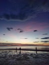 Beautiful sunset on the beach and three people Royalty Free Stock Photo