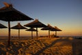 Beautiful sunset on a beautiful sandy beach with sunshades.Straw umbrellas on a beautiful tropical beach.Panorama of a