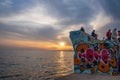 Beautiful sunset scene of people enjoying themselves on a concrete construction at the seafront in Palaio Faliro in Athens, Greece