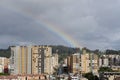 Beautiful sunset scene of a rainbow in middle of two residential buildings at bogota