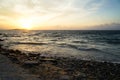 Beautiful sunset scenic copyspace wavy seaview and natural rock beach with beautiful shades of orange and blue sky background Royalty Free Stock Photo