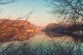 Beautiful sunset scenic image of Lake Bohinj and old Slovenian village Stara Fuzina in background seen through branches of Royalty Free Stock Photo