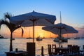 Beautiful sunset on the sea beach cafe or restaurant, boats, ships and yachts silhouettes on water background Royalty Free Stock Photo