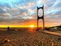 Beautiful sunset at sea maritime bridge gate in the sun light beach people walking romantic couple stay on sand reflection on sea