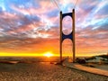 Beautiful sunset at sea maritime bridge gate in the sun light  beach people walking romantic couple stay on sand reflection on sea Royalty Free Stock Photo