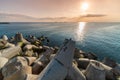 Beautiful sunset seascape. Breakwaters tetrapods ashore of pier. Cargo ships on the horizon. Travel dreams and motivation Royalty Free Stock Photo